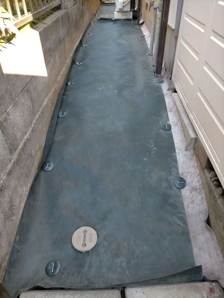 犬走り（長さ8m×幅1.1m・約8.8㎡）にデュポン ザバーン240G防草シートをコ型ピン・防草ワッシャーで0.5〜1m間隔に固定した施工完了状態。この後石灰砕石800kgを敷く