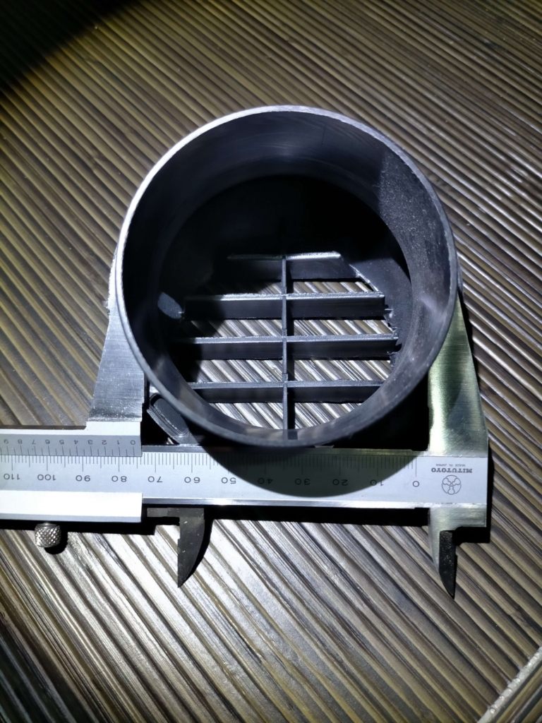 中華FFヒーター用75mm温風吹き出し口グリル(BSTQC製排気インテークパイプ対応品)の実物写真。ダクト交換・吹き出し口増設時の形状・サイズ確認用。車内壁面への取り付けネジ穴配置と吹き出し口の口径確認