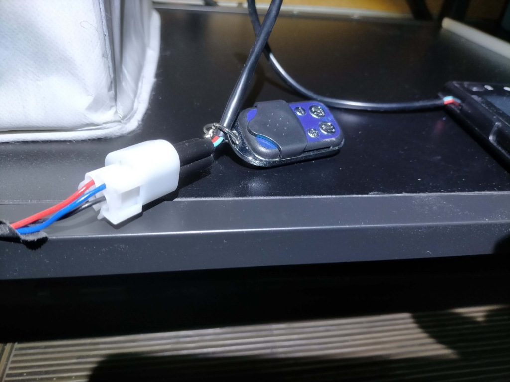 中華FFヒーターのディスプレイパネル黒コネクタをヒーター本体側の青い通信回線に接続した状態の写真。E-07「ディスプレイパネルが接続されていません」エラーのトラブルシューティングで最初に確認すべき接続箇所。接触不良や断線がないか目視チェックするポイント