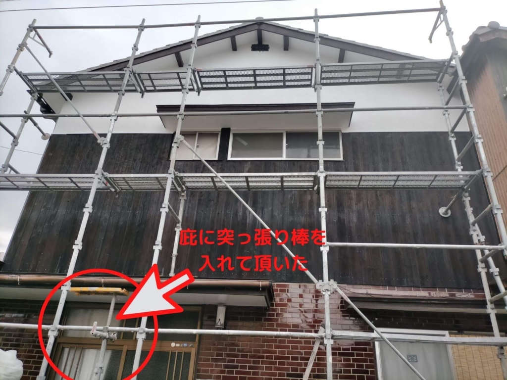 クサビ式足場の組立後、強度的に不安がある玄関ひさし（庇）の上に足場の柱が乗っていたため、足場業者に依頼して庇の内側に突っ張り棒を入れて補強した状態。足場組立時の注意点
