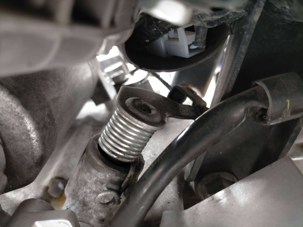 セロー250のクラッチワイヤーエンジン側レバーのスプリング引っ掛けを外してクラッチレバーを軽くする裏技。上から撮った写真