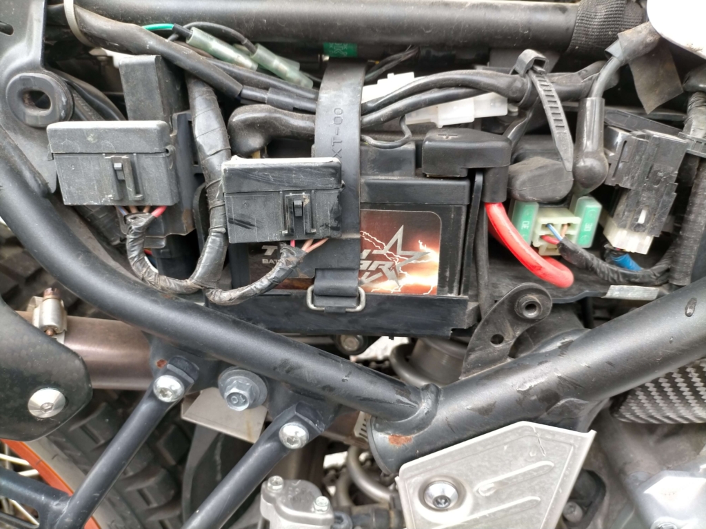 セロー250（DG17J）に搭載したDRC タフスター102型リチウムバッテリー（D45-09-102・重量0.5kg・LiFePO4）。純正YTZ7Sの2.1kgからマイナス1.6kgで重心低下・引き起こし軽量化に貢献