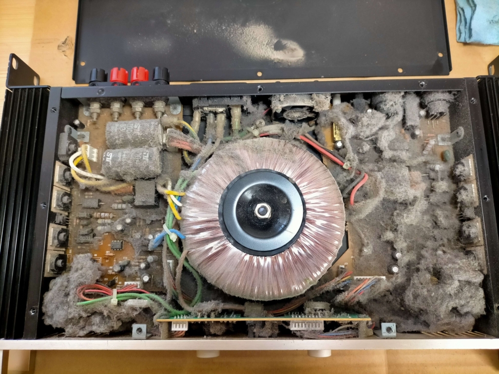 Classic Pro CP400内部の清掃前の状態。業務用中古アンプ特有の長年のホコリが基板・ファン・トランス周辺に堆積した状態。掃除機とエアコンプレッサーで清掃前