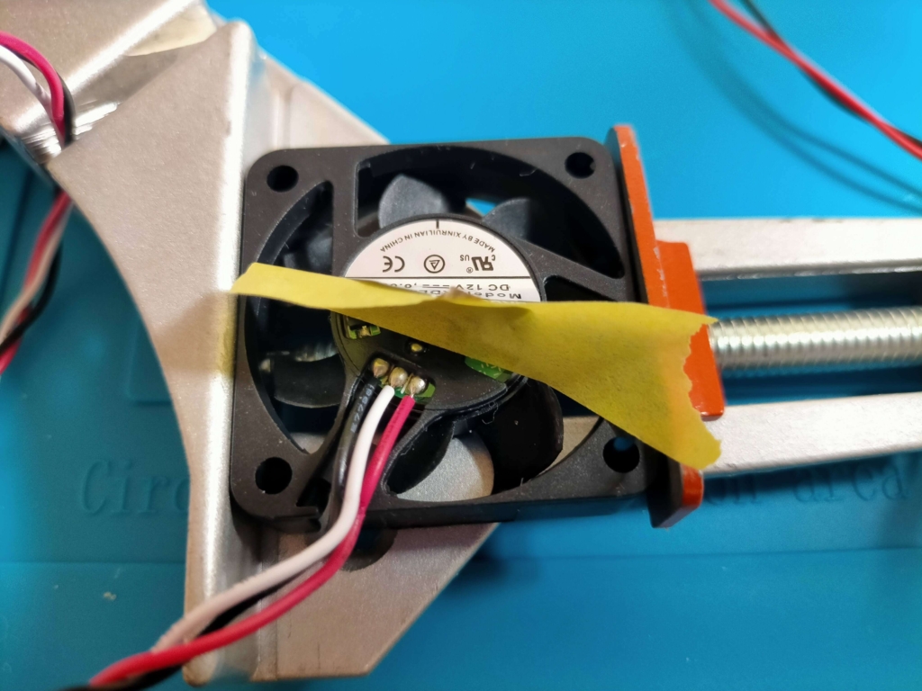 長尾製作所 RDL4010S静音ファンの3ピンコネクタ（赤：＋12V・黒：GND・白：パルスセンサー）。CP400アンプ側の2ピンコネクタに接続するため白いパルスセンサー線は不使用で赤・黒のみ移植ハンダ付けする配線加工前の状態