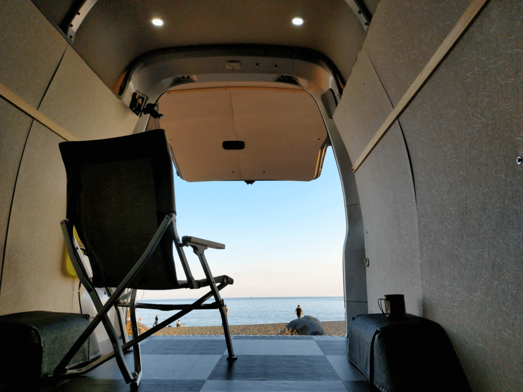 LiTime LiFePO4 12V 100Ah自作ポータブル電源を搭載したバンで海辺に駐車した車中泊（バンライフ）の様子。コーヒーメーカーなどの家電も砂浜で使用可能