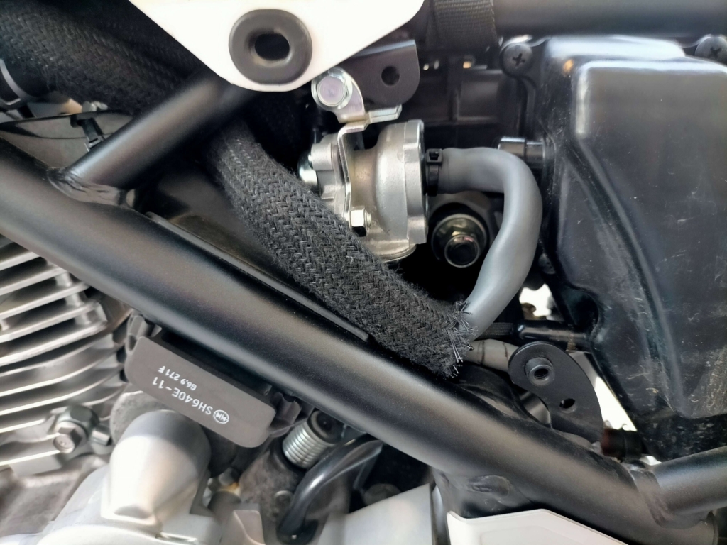 セロー250のシリンダーヘッド付近に改造済みAIS内圧コントロールバルブを固定し、シリンダーヘッドブリーザーホース（B）とエキゾーストポートホース（C）の2本を接続して取り付けた状態