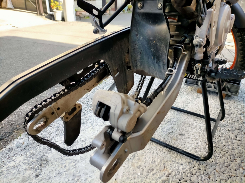 セロー250のリヤホイールをアクスルナット(19mm)・アクスルシャフト(22mm)を外しチェーンを切り離して取り外した状態