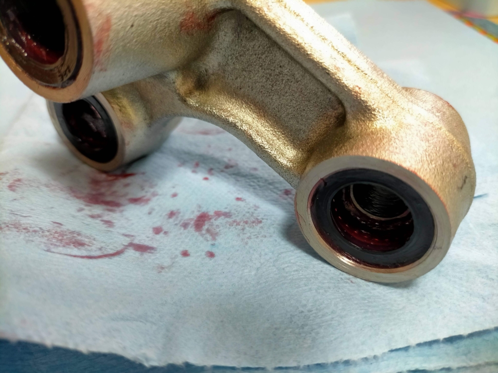 セロー250リレーアームの破損した樹脂保持器を除去し、ベアリングコロのみをFUCHS SILCOLENE PRO RG2グリスで内壁に貼り付けてカラーを半挿入した応急処置・再組立て状態