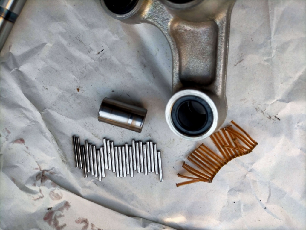 セロー250リレーアームの純正ベアリングからカラー(スペーサー)・ベアリングコロ・破損した樹脂製保持器を取り外した状態