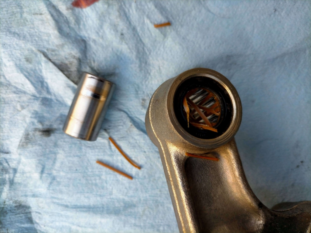 セロー250リレーアームのエアーブロー清掃中に破損した純正ベアリング樹脂製保持器(リテーナー)と若干の焼けが見られるカラー(スペーサー)の状態