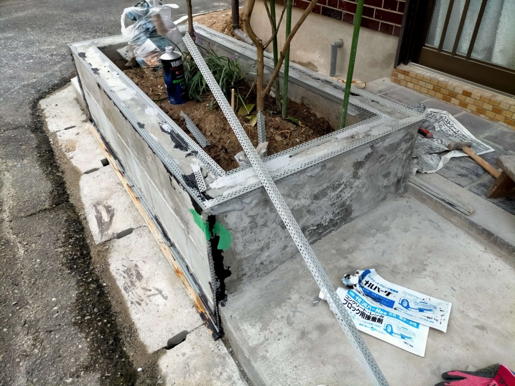 松煙墨モルタル仕上げの精度を上げるためフクビ化学ニューツーウェイコーナー定規を養生テープとナルシルバー・ナルパークで花壇コーナーに固定した状態(9月27日)