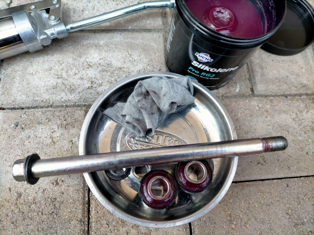 セロー250フロントホイール組み付け前にアクスルボルトとカラーにグリスを塗布しているグリスアップ作業