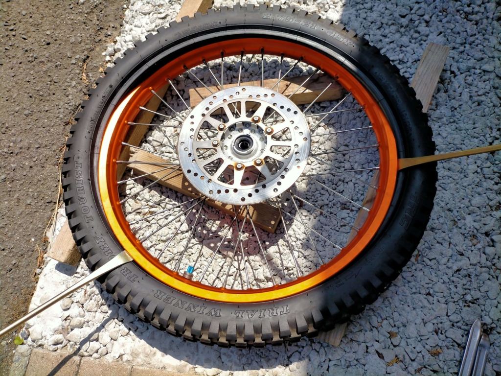 セロー250フロントホイールからタイヤレバーを使ってタイヤとチューブをリムから取り外している作業