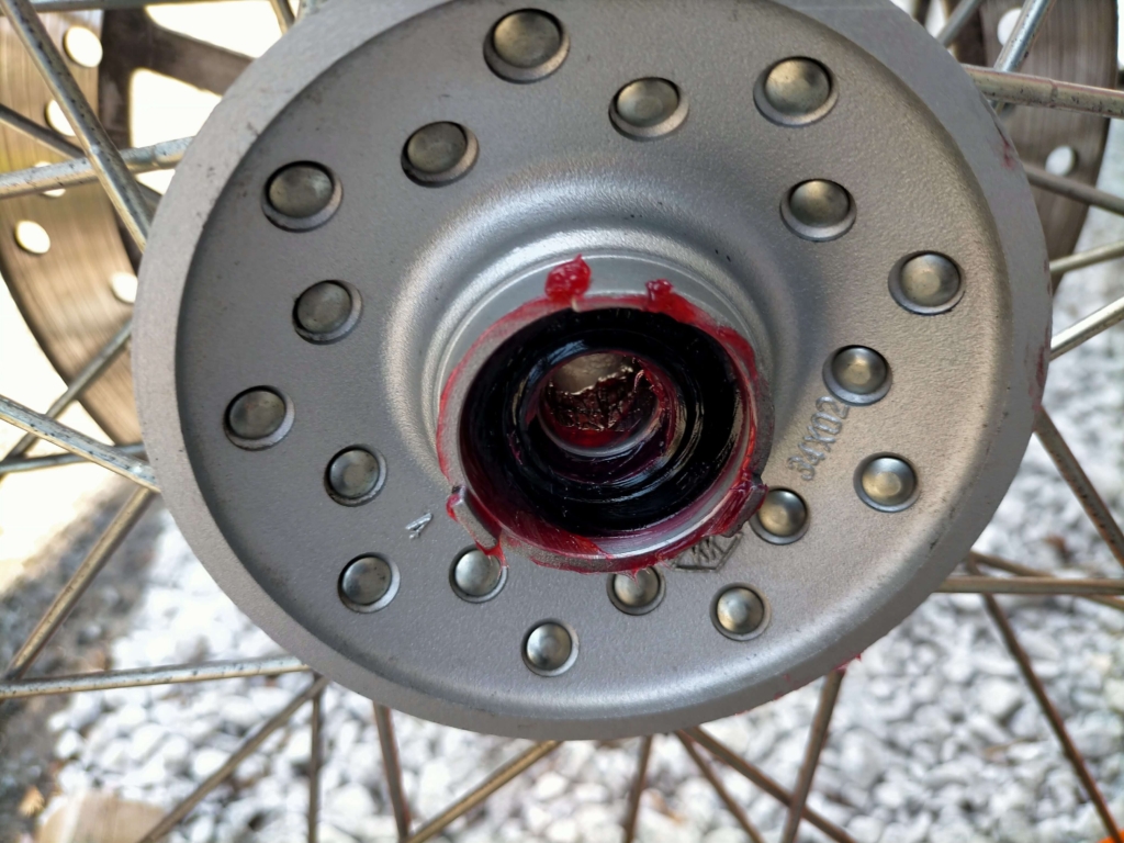 セロー250フロントホイールのオイルシール・ホイールベアリング・スペーサーにグリスを塗布しているグリスアップ作業