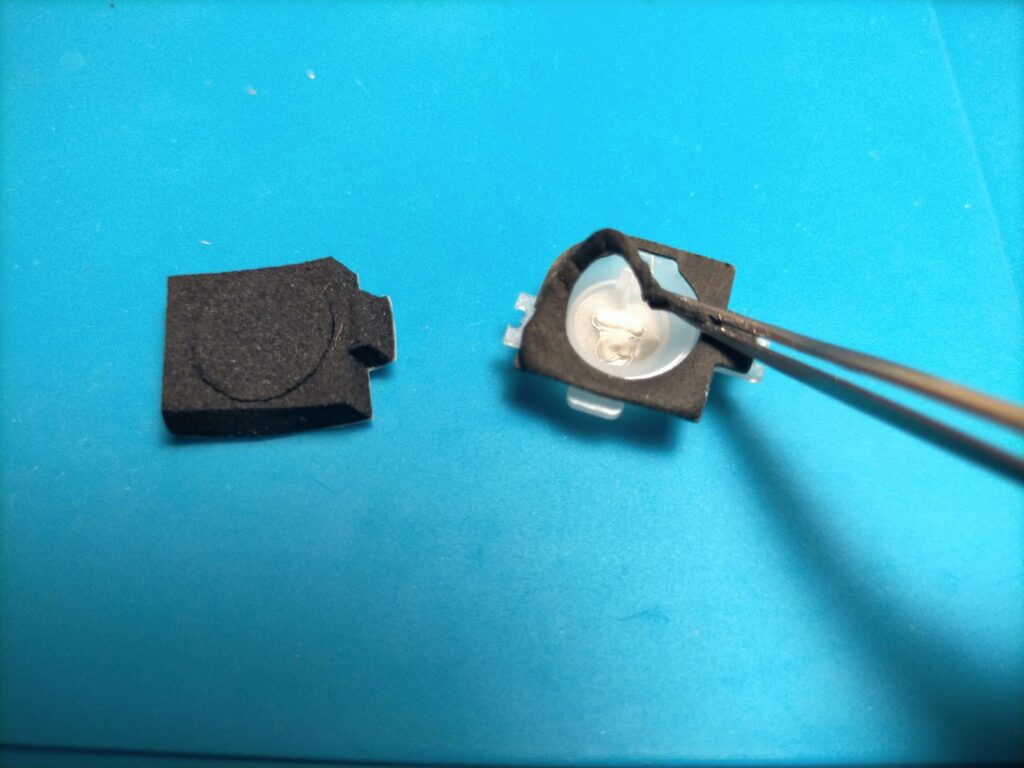 dynabook T45の電源ボタン裏面のへたって陥没の原因となったスポンジをピンセットで取り除いている作業