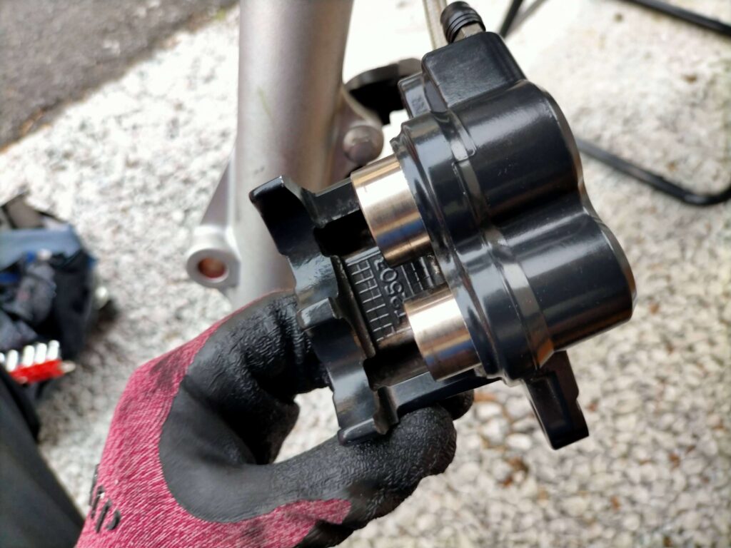 セロー250フロントブレーキキャリパーのピストンをブレーキパーツクリーナーとウエスで清掃した様子