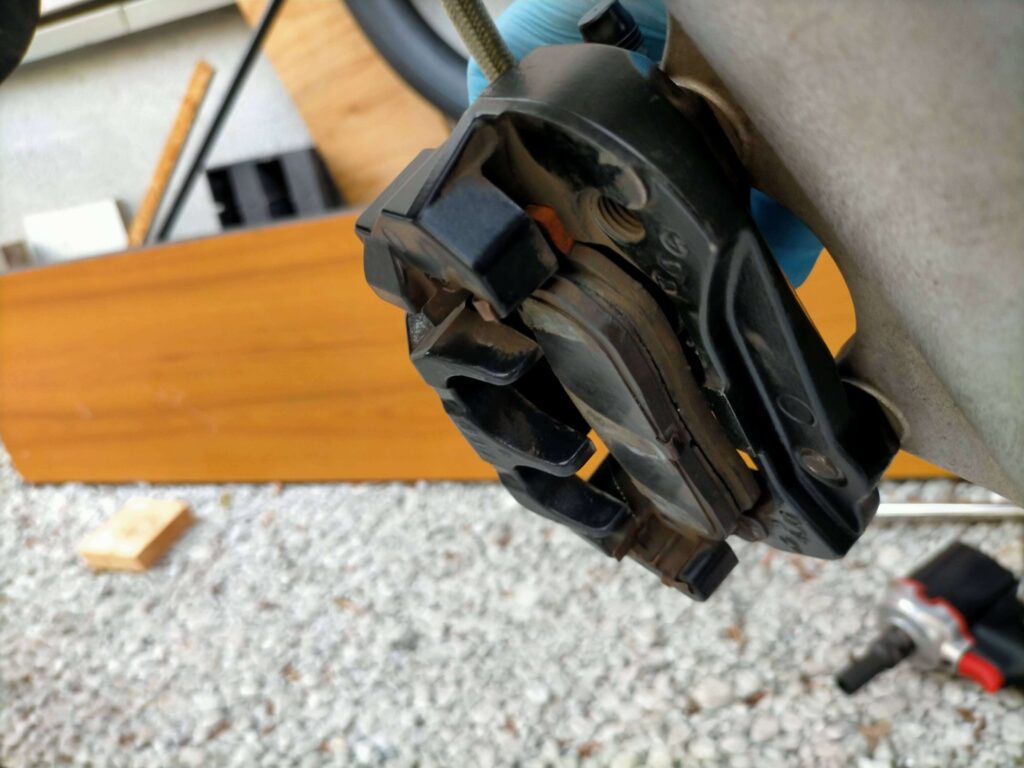 セロー250フロントブレーキキャリパーとキャリパーサポートボルト（12mm）の位置を示す車体右側からの写真