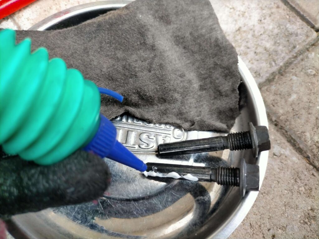 セロー250フロントブレーキキャリパーのスライドピン兼用サポートボルト（12mm）にシリコングリスを塗布している作業