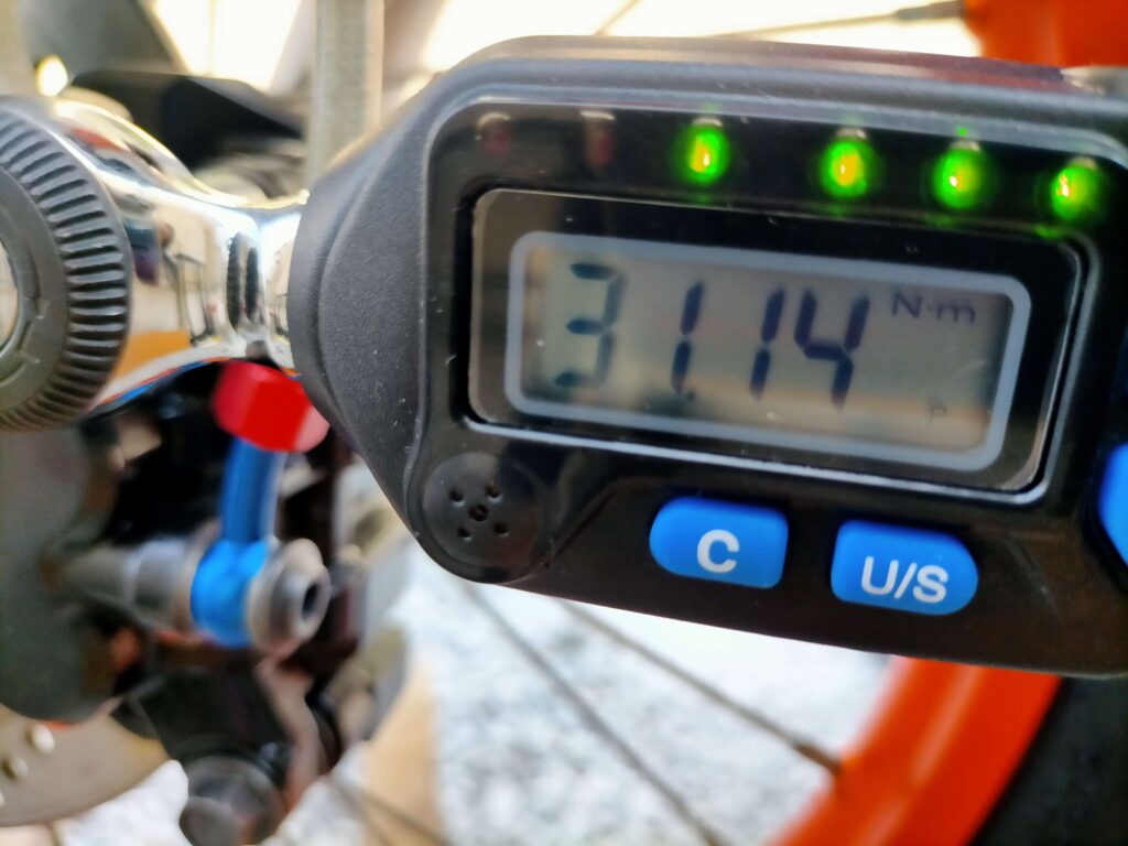 デジタルトルクレンチでセロー250フロントブレーキキャリパーサポートボルトを規定トルク31Nm（3.1kgf・m）で締め付けている作業