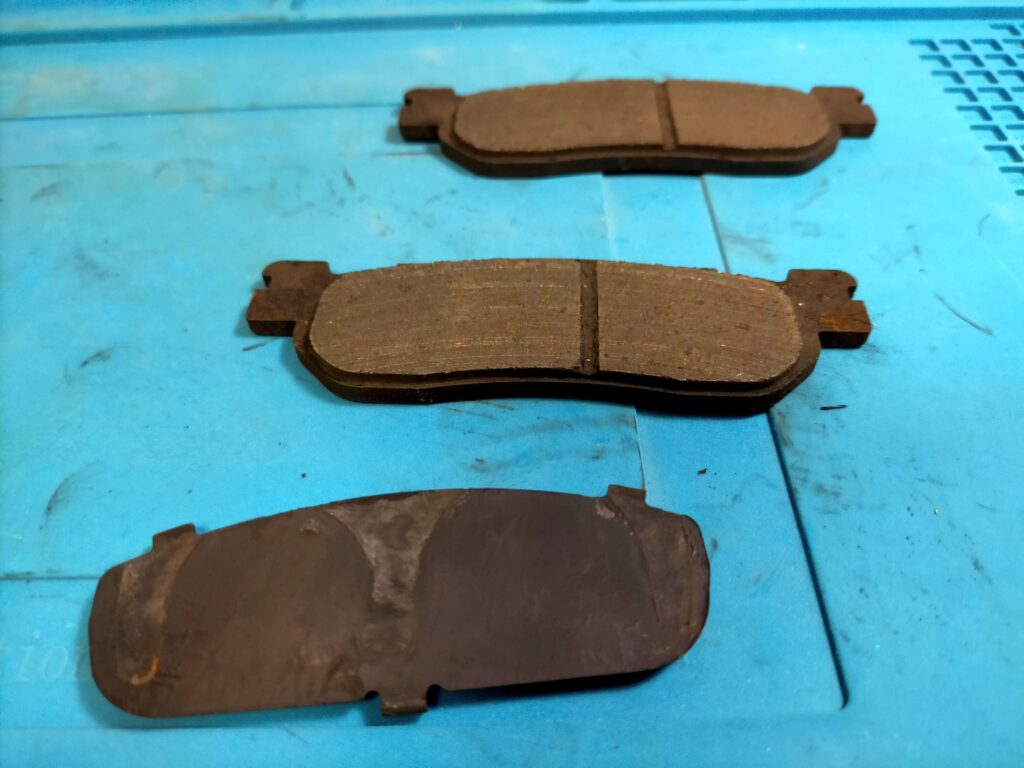 セロー250から取り外した純正フロントブレーキパッド2枚（走行7,950km・残り2.2mm）と純正シムの状態