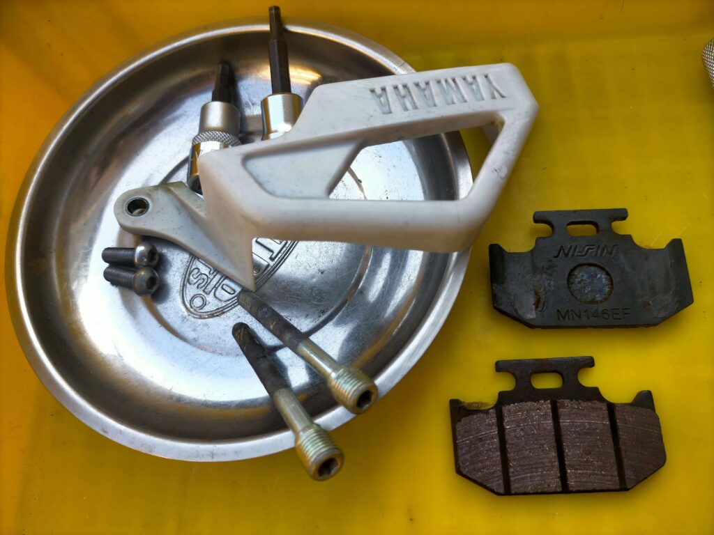 セロー250リヤブレーキパッドまで取り外した際の部品一式（パッド・サポートボルト・スプリング）と使用工具の全体