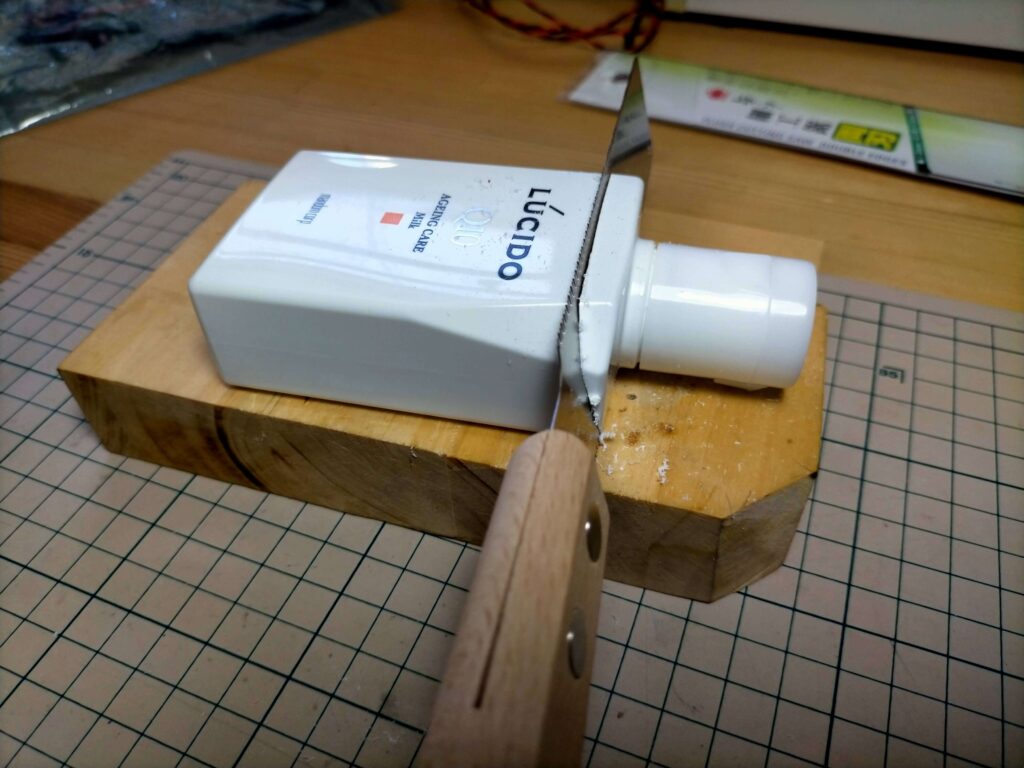 乳液の空き箱をダボ切りノコギリでカットしてコントローラーケースに加工している途中の様子