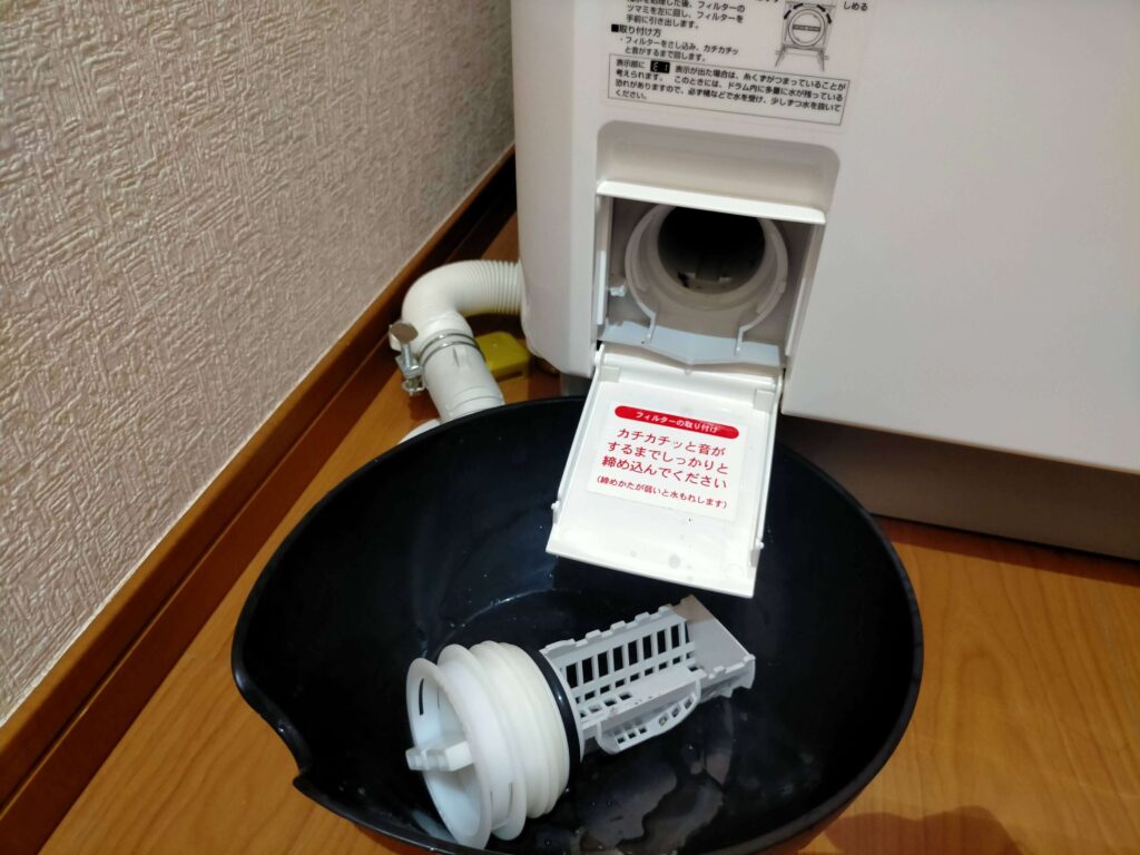 東芝ドラム式洗濯機の糸くずフィルターを外す（E1エラーの場合水も出てくるので桶を用意して少しずつ水を出す）
