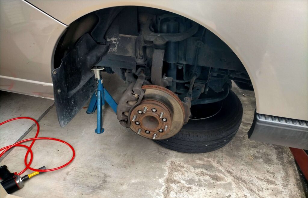 ジャッキアップした車をジャッキスタンド（ウマ）で確実に固定しタイヤを外している様子