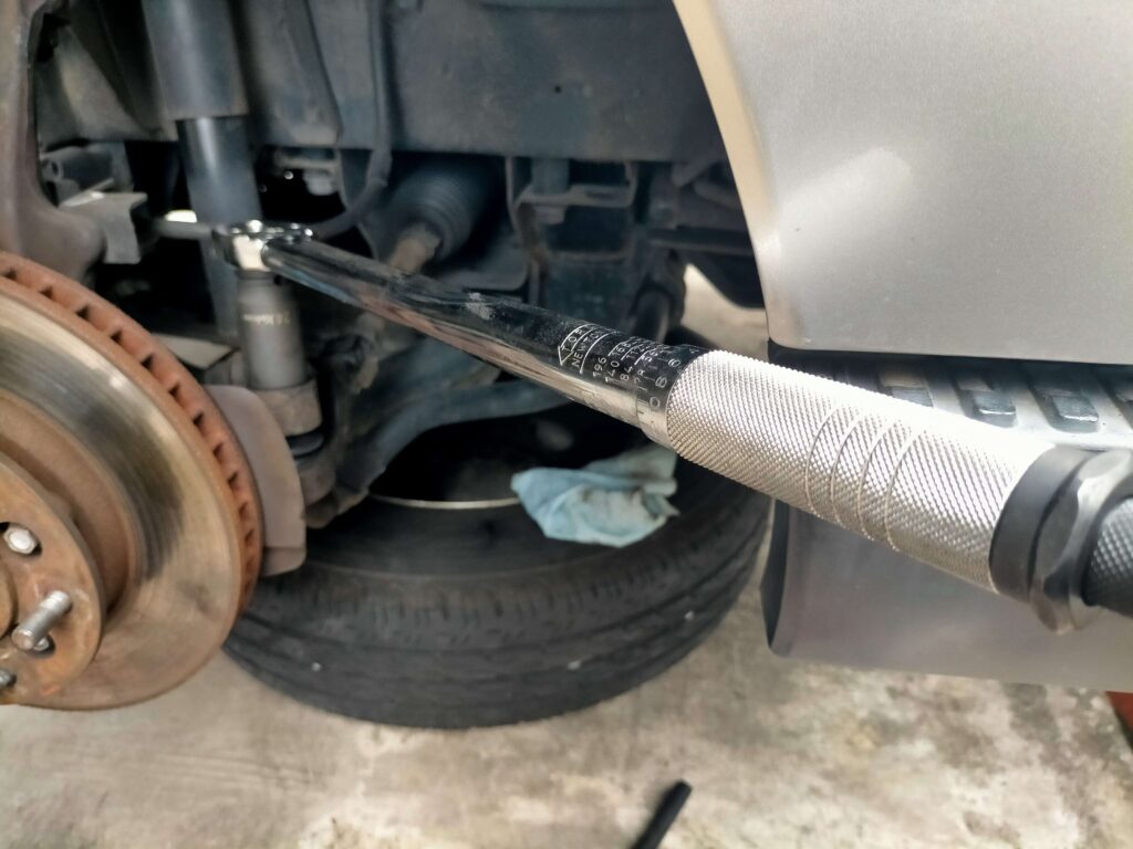 トルクレンチでタイロッドエンドナットを規定トルクに締め付け