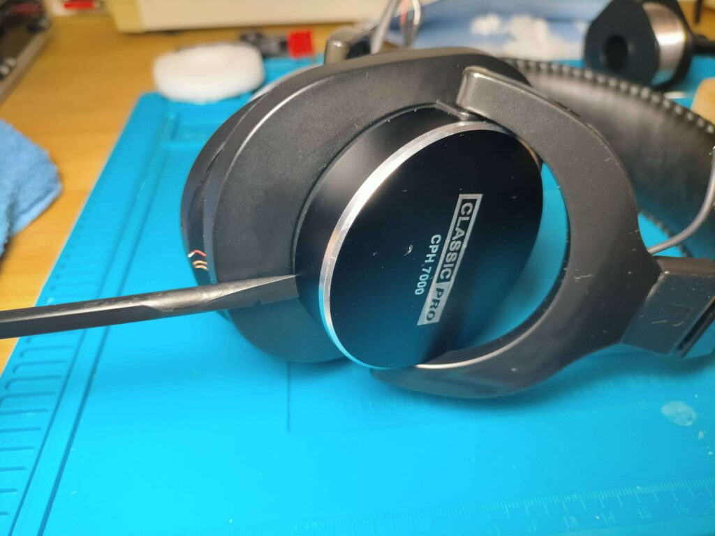 CPH7000BTの右ハウジング外側のアルミカバーをこじ開けて分解している様子