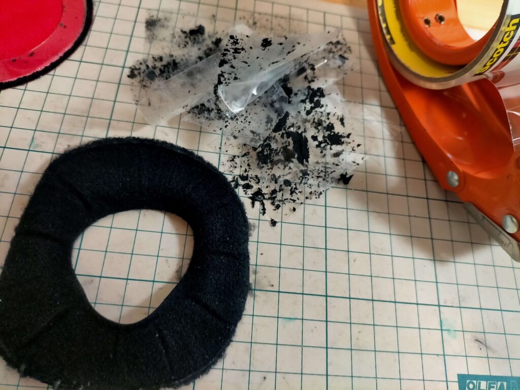 再使用する黒いパーツのボロボロの合皮をテープで取り除く