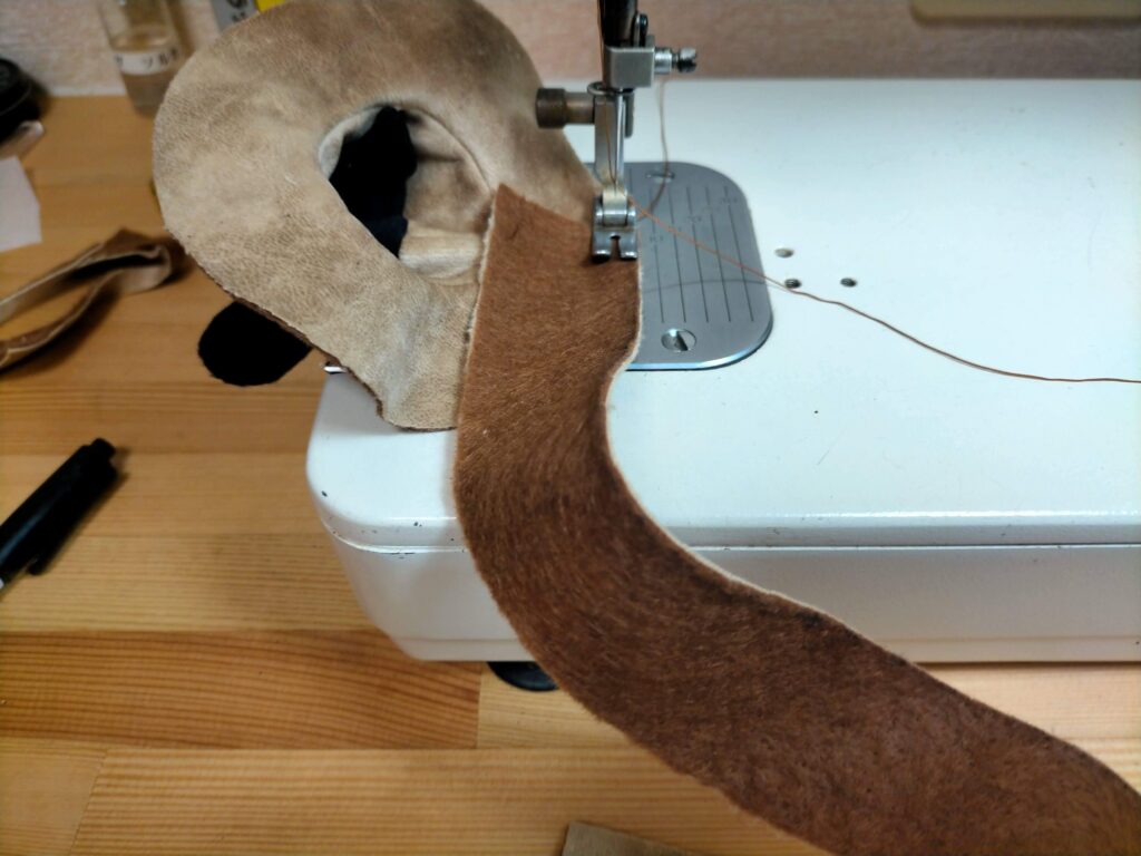 イヤーパッドの外側面と耳に当たる部分の生地を縫い合わせる作業