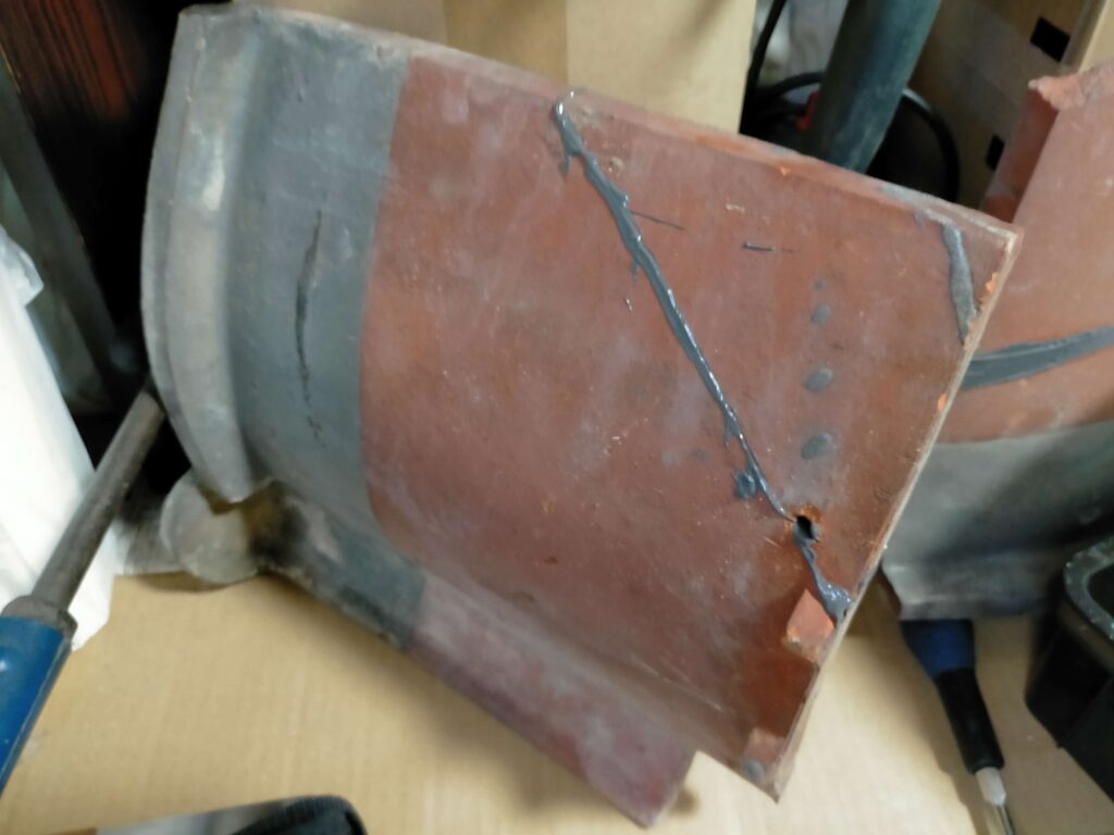接着剤を塗布し、破片を貼り合わせて乾燥させている瓦（その1）