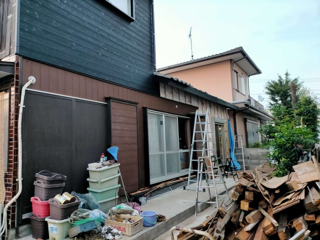 修理した瓦を屋根の軒先に戻して設置している作業風景