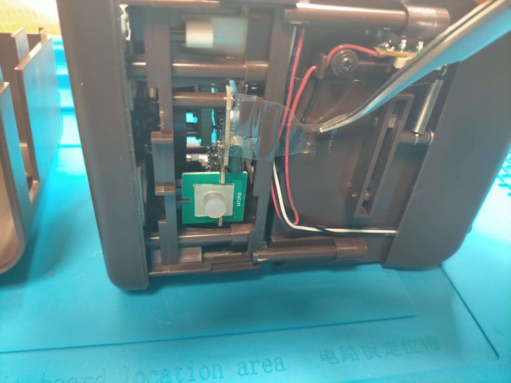 バンクマン上内部のセンサー類の配線を固定しているテープを外している様子