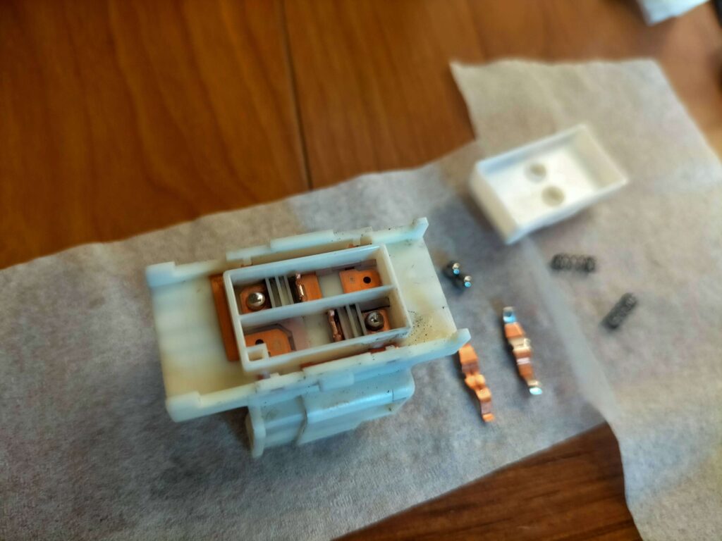 E25キャラバン(いすゞコモ)パワーウィンドウスイッチ清掃後の組み立て作業(金属ボール2つを乗せる)