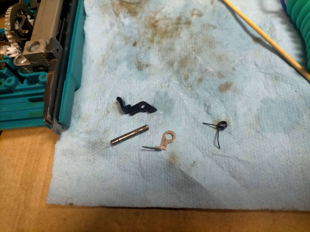 分解されたステープル切れ検知スイッチと関連パーツ