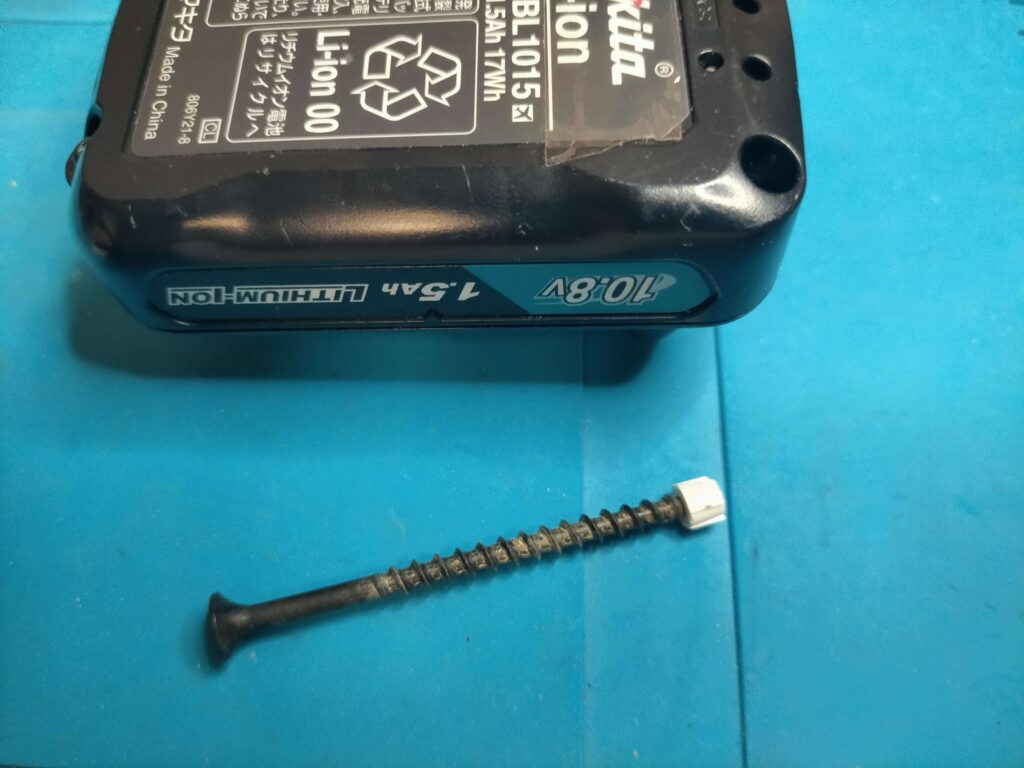 BL1015の白い樹脂詰め物(封印)にビスをねじ込んで引き抜く作業