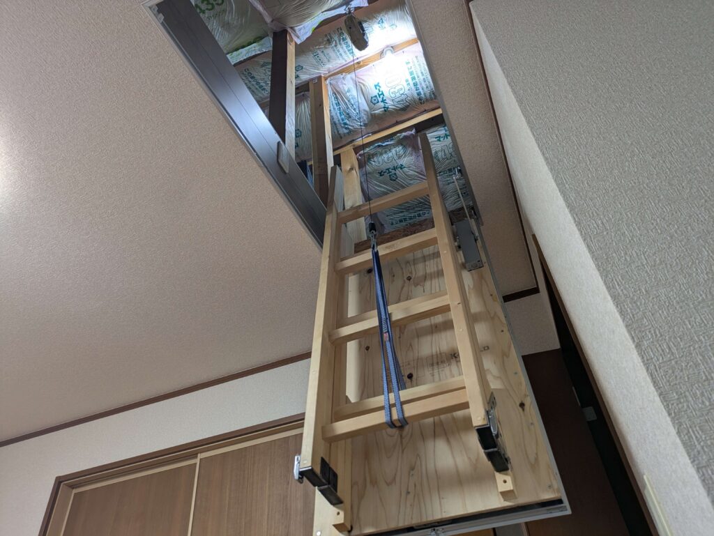スプリングバランサーのフックとはしごをスリングで接続して扉を開閉