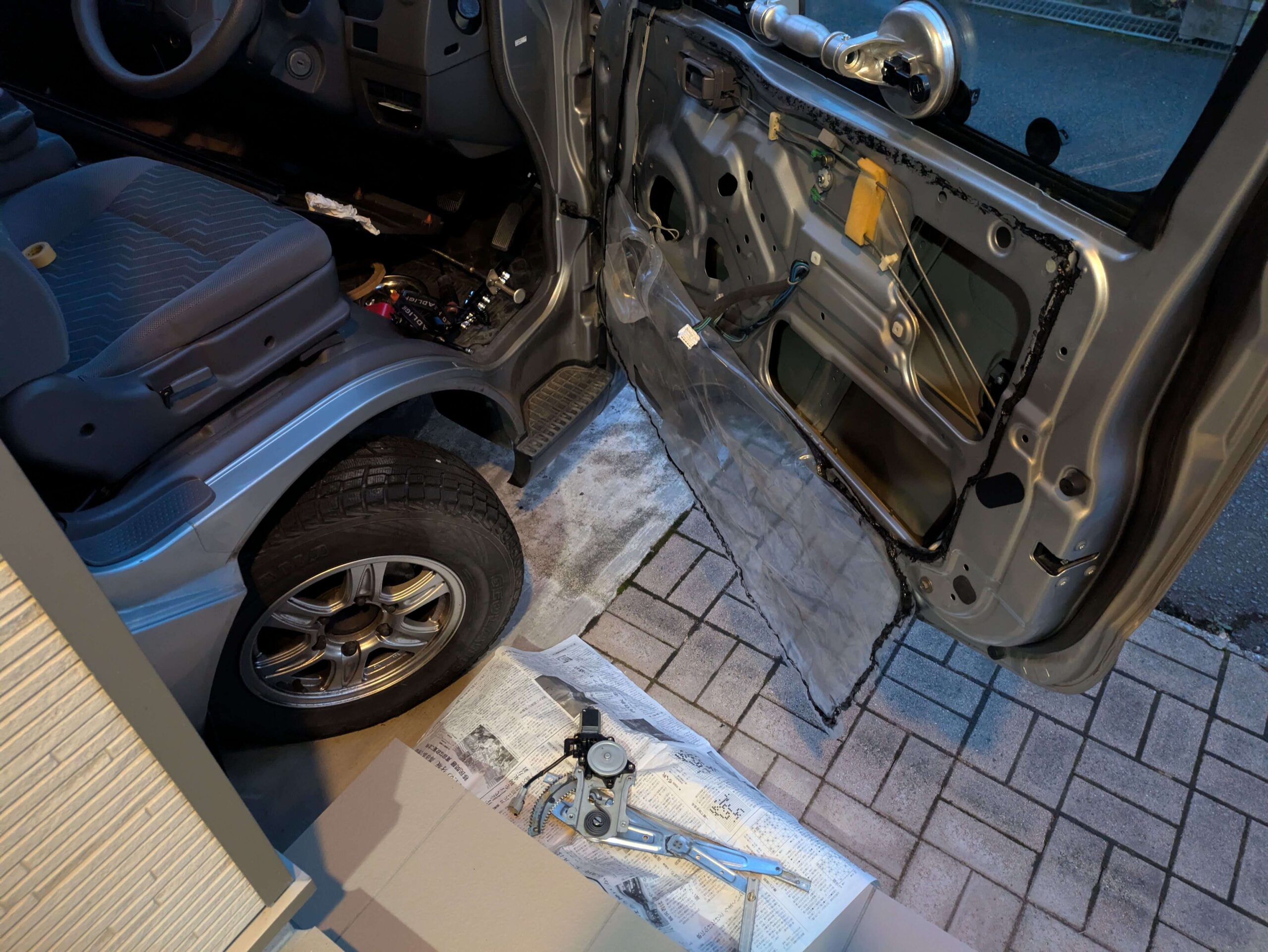 ドア内部から取り出された、パワーウィンドウ修理のためのウィンドウレギュレーターアッセンブリ全体