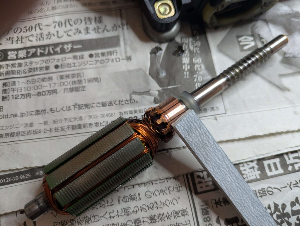 E25レギュレーターモーターの整流子をペーパーで研磨する作業