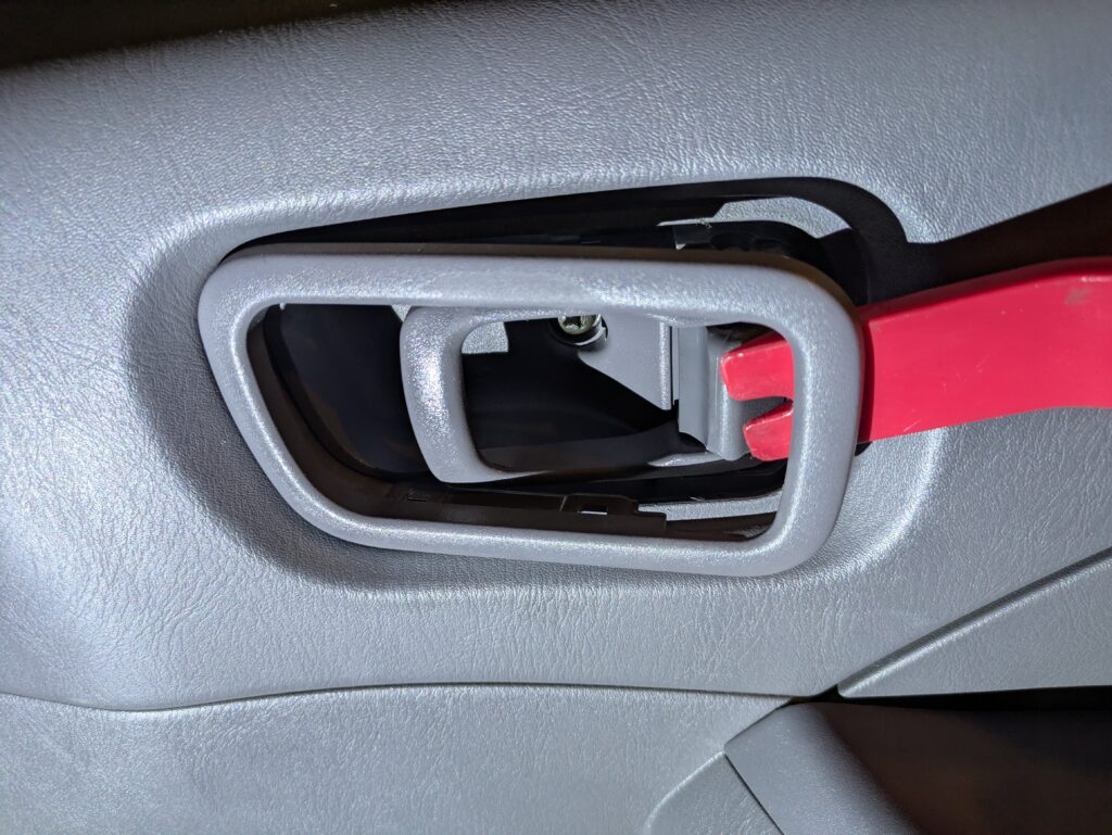 E25キャラバンのインサイドハンドル奥のエスカッション（化粧パネル）を外す作業