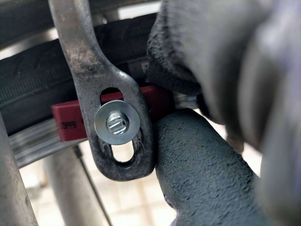 新しい自転車ブレーキシューをブレーキアームに取り付けている作業