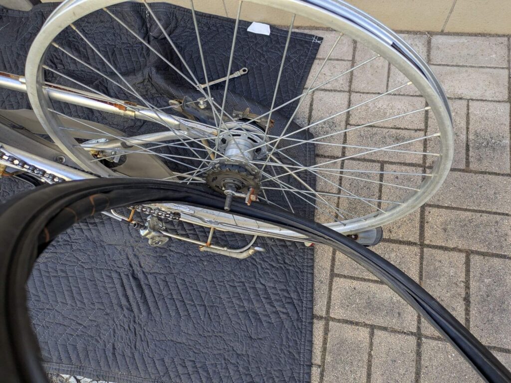 車体とチェーン側ハブ軸の間の隙間からタイヤとチューブを抜く（ブレーキワイヤーを外さない方法）