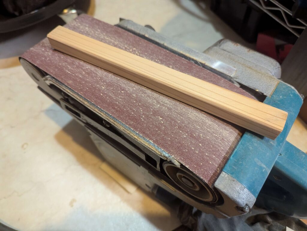 足材をベルトサンダーで整える