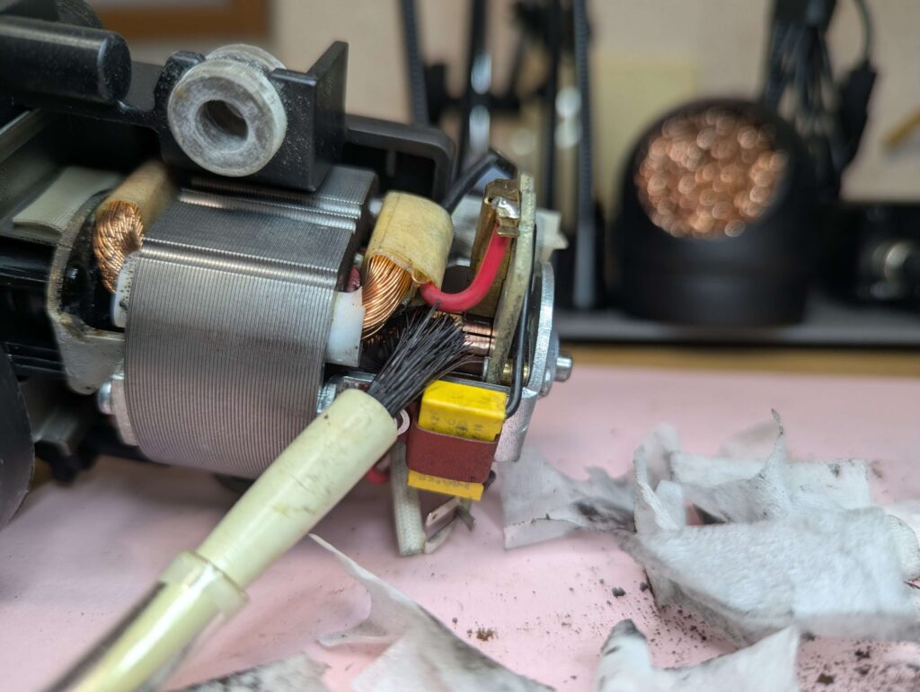 整流子の溝に詰まったカーボンカスをブラシで徹底的に清掃する作業