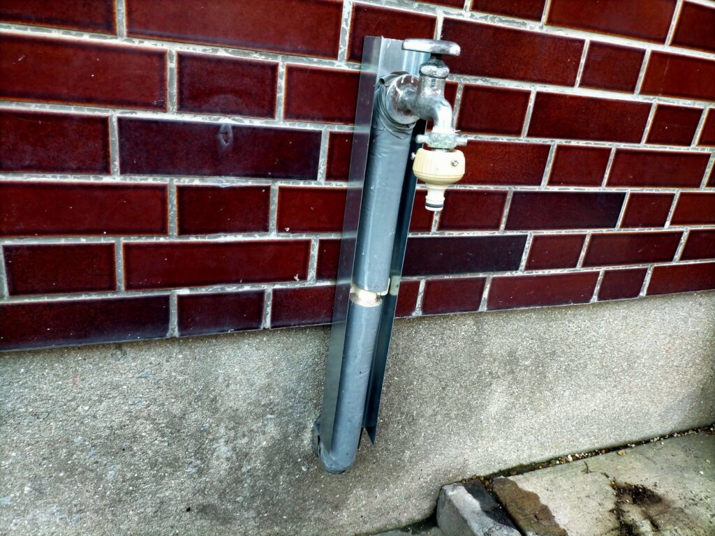 水道管カバーの背面用軽天を仮あわせして上端の折り返し位置を確認している様子