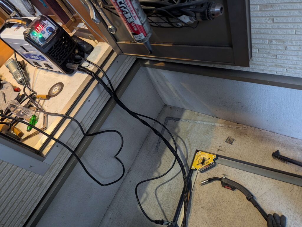 駐車場のスペースで行うアイアンフレームの半自動溶接作業