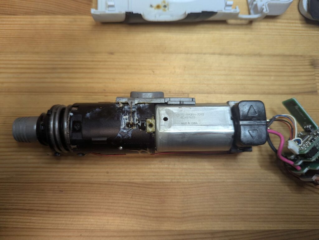 取り出したモーター、スイッチ、回路基板、ギアボックス、配線