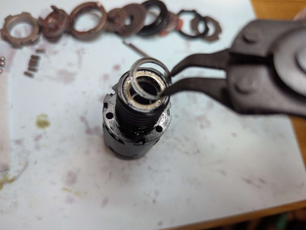 軸を固定しいるスナップリングを外す